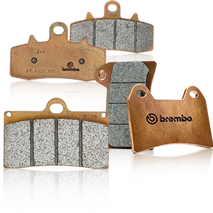 Varias pastillas de freno Brembo para motocicletas con acabado en cobre y superficie de fricción gris.